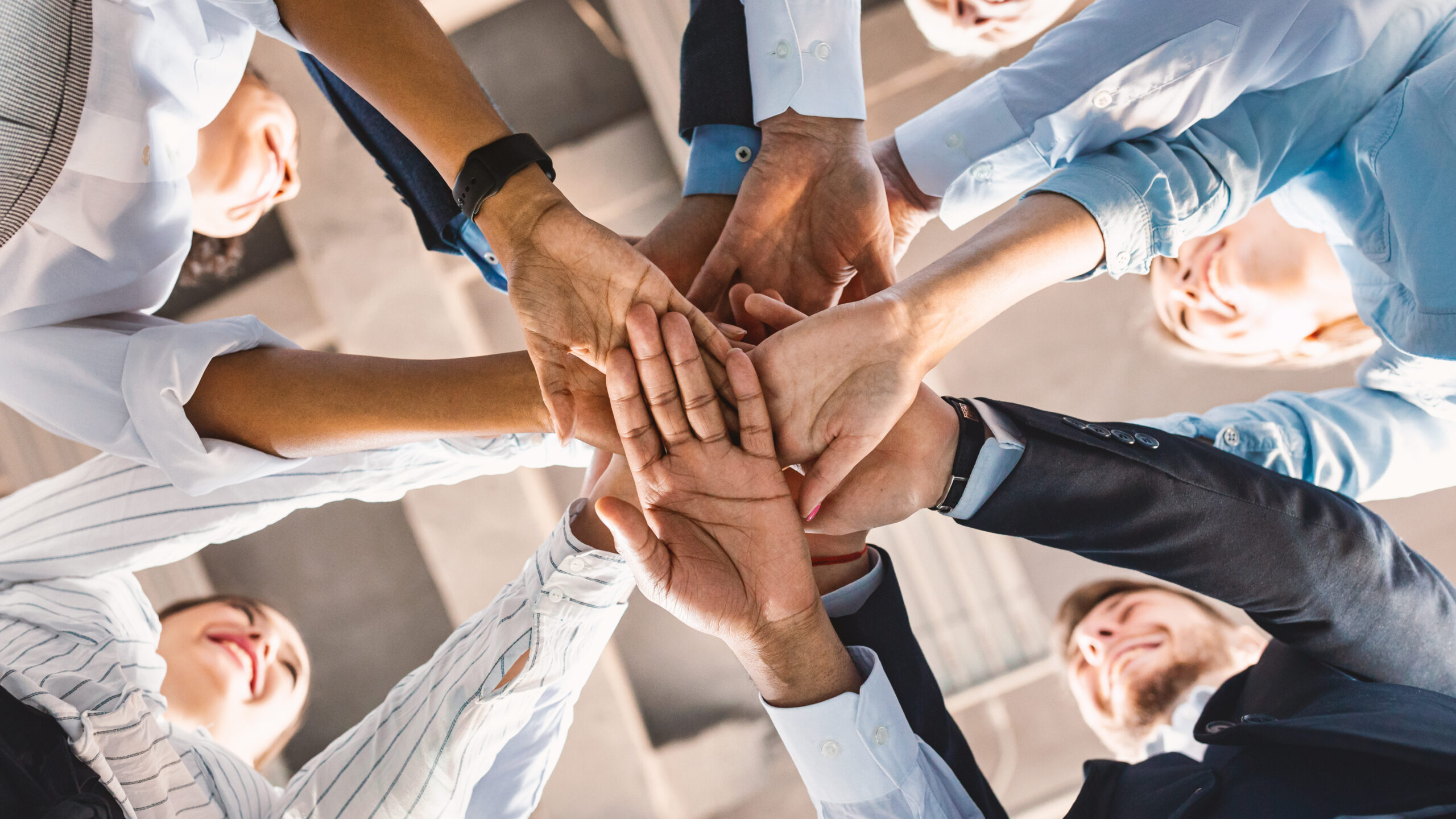 Coworkers Standing In Circle Holding Hands In Office, Panorama, Bottom-View