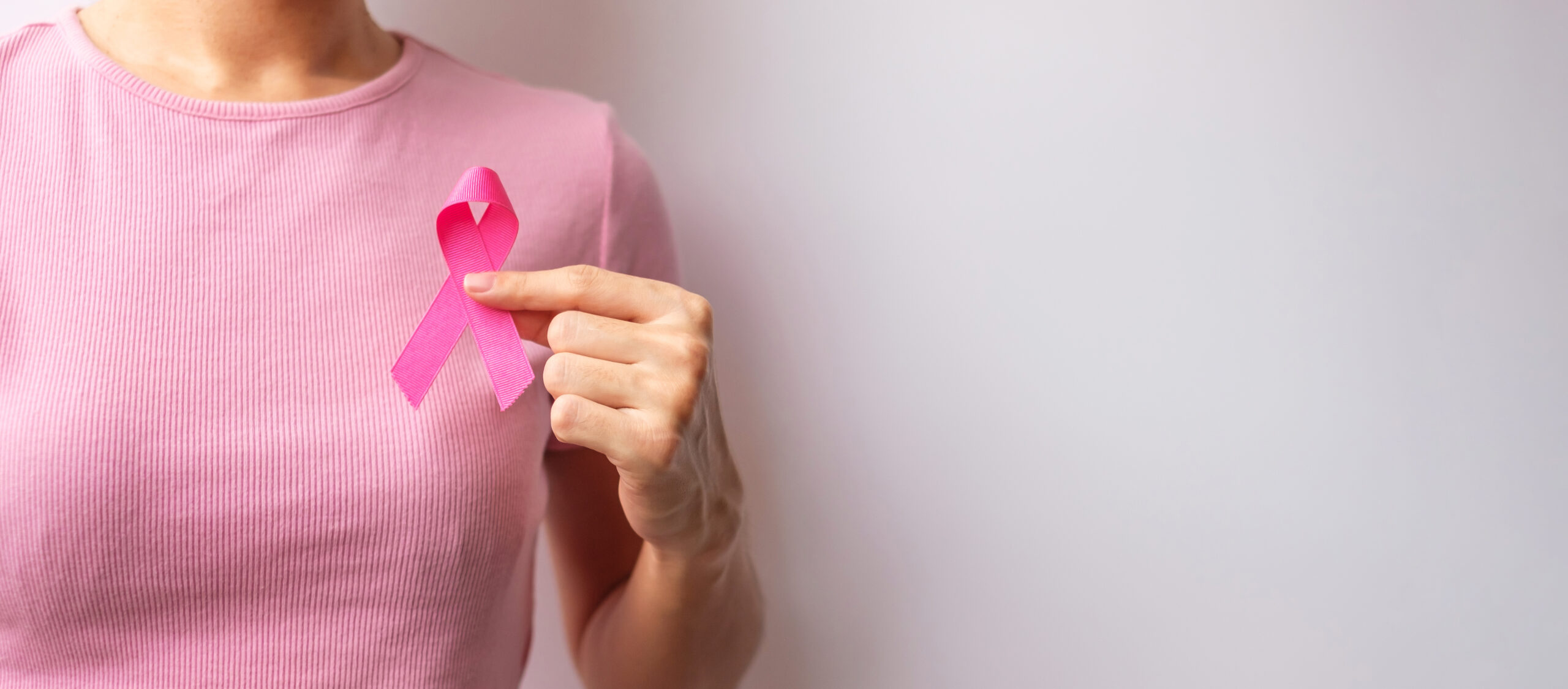 Pink October Breast Cancer Awareness month, woman hand hold pink Ribbon and wear shirt for support people life and illness. National cancer survivors month, Mother and World cancer day concept